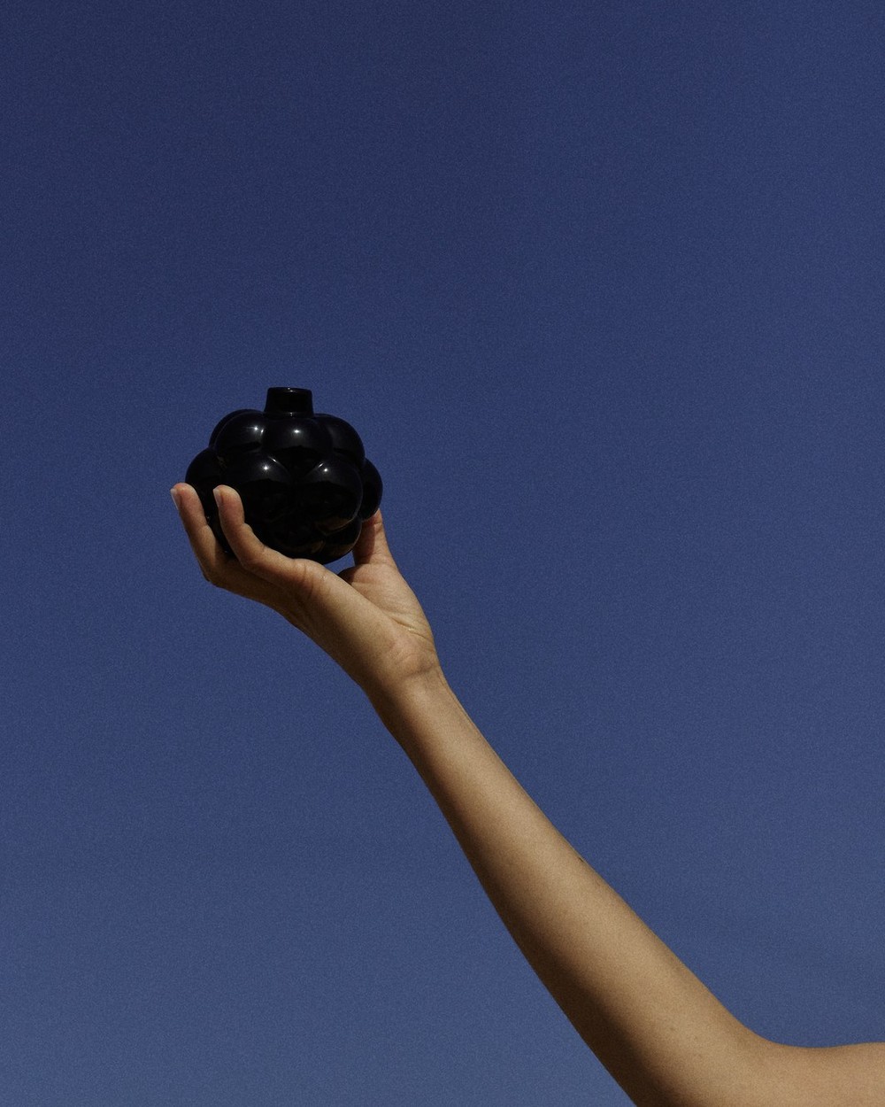 Black Zaaman Cloud 9 ceramic vessel held up against blue sky